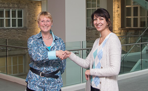 Zahra Haghshenasfard (right) accepts award from Grad. Chair Silvia Mittler